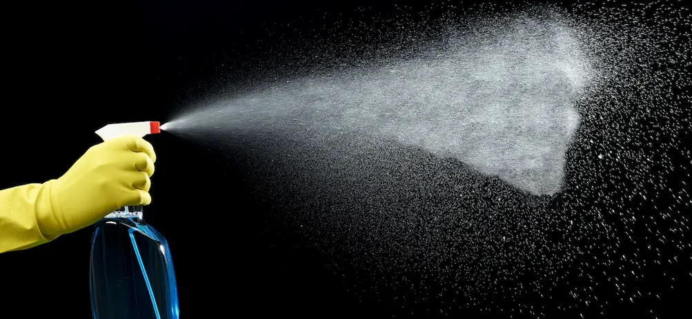 Jemand sprüht mit einer Sprühflasche eine große Nebelwolke